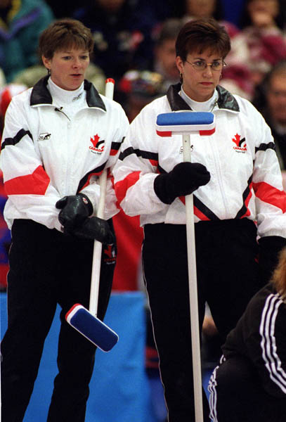 Canada's Jan Betker (L) and Sandra Schmirler watch as their opponents take their turn during a curling match at the 1998 Nagano Winter Olympics. (CP PHOTO/COA)