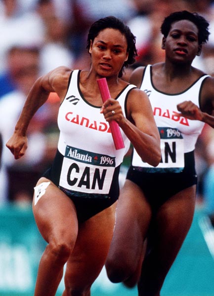 Leslie Tashlin (gauche) et Ladonna Antoine du Canada participent  une preuve de relais aux Jeux olympiques d'Atlanta de 1996.(PC Photo/AOC)