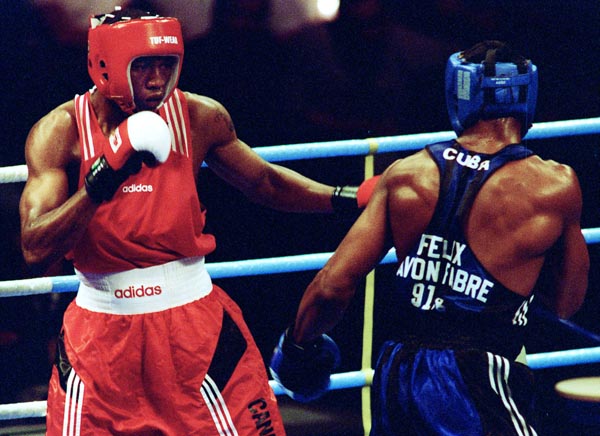 Canada's David Defiagbon (left) in action boxing against his opponent Felix Savon of Cuba at the 1996 Atlanta Summer Olympic Games. (CP PHOTO/COA/Mike Ridewood)