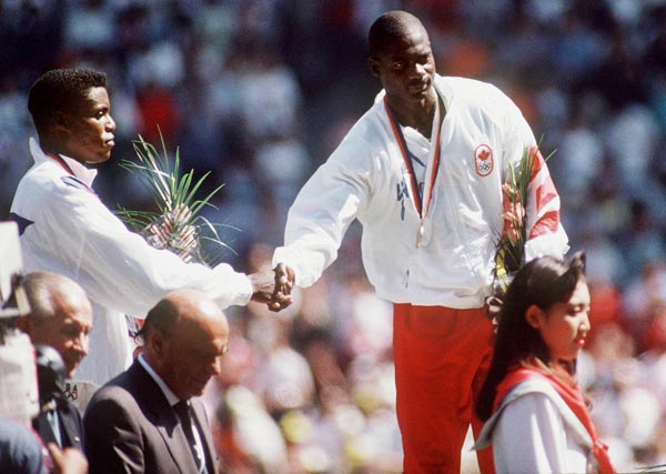 Canada's Ben Johnson (right) celebrates his gold medal win in the 100m race along with silver medal winner Carl Lewis (left) at the 1988 Olympic games in Seoul. (CP PHOTO/ COA/ Cromby McNeil)