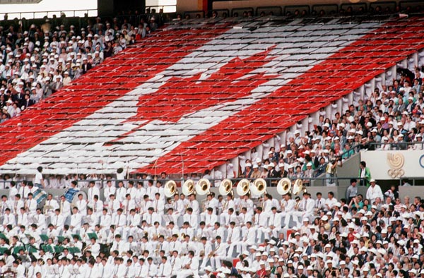 Participants form a Canadian flag in the stands during the opening ceremonies of the 1988 Olympic games in Seoul. (CP PHOTO/ COA/ Cromby McNeil)
