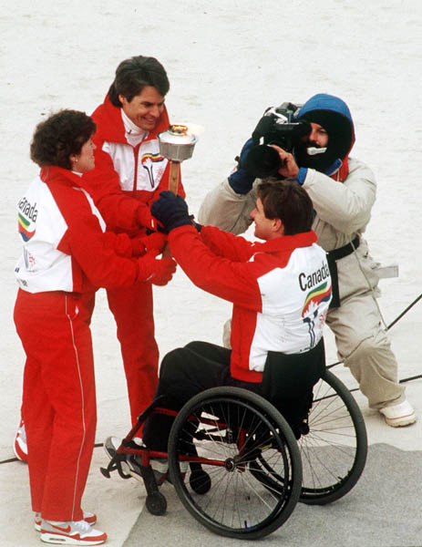 Canada's Cathy Preistner (left) and Ken Read (centre) receive the olympic flame from Rick Hanson during the opening ceremonies of the 1988 Winter Olympics in Calgary. (CP PHOTO/COA/ T. O'lett)