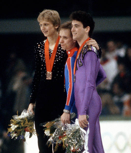 USA's Scott Hamilton (centre) and Brian Orser (right) celebrate after winning the gold and silver medals in the figure skating event at the 1984 Sarajevo Winter Olympic Games.(CP Photo/ COA/ Crombie McNeil)