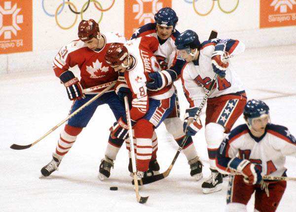 Canada's Vaughn Karpan (left) and Dave Tippett (8) compete in hockey action against the United States at the 1984 Winter Olympics in Sarajevo. (CP PHOTO/ COA/O. Bierwagon )