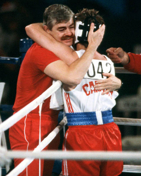 Canada's John Kalbhenn (right) hugs his trainor during a boxing event at the 1984 Olympic games in Los Angeles. (CP PHOTO/ COA/ Tim O'lett)