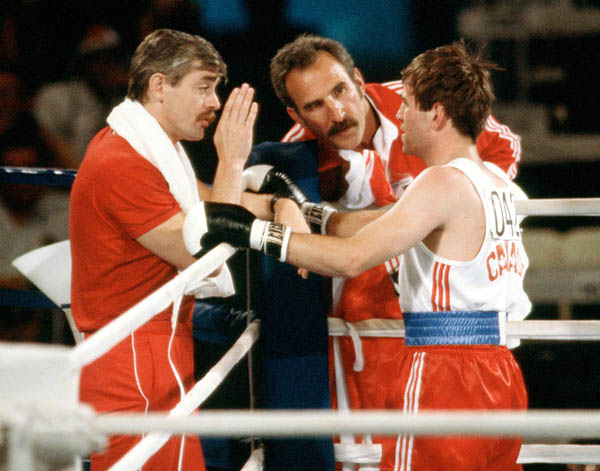 Canada's John Kalbhenn (right) receives instructions during a boxing event at the 1984 Olympic games in Los Angeles. (CP PHOTO/ COA/ Tim O'lett)