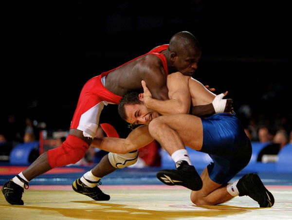 Canada's Daniel Igali (red) participates in wrestling action against opponent Arsen Gitinov of Russia at the 2000 Sydney Olympic Games. (CP Photo/ COA)