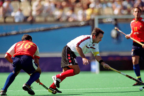 Canada's Peter Milkovich (white) participates in field hockey action at the 2000 Sydney Olympic Games. (CP Photo/ COA)