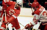 Canada's Dan D'Avise (left) fights for control the puck with Poland's Andrzej Malysiak during hockey action at the 1980 Winter Olympics in Lake Placid. (CP Photo/ COA)