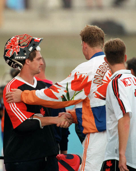 Canada's Mike Mahood (left) shakes hands with the team from the Netherlands during field hockey action at the 2000 Sydney Olympic Games. (CP Photo/ COA)