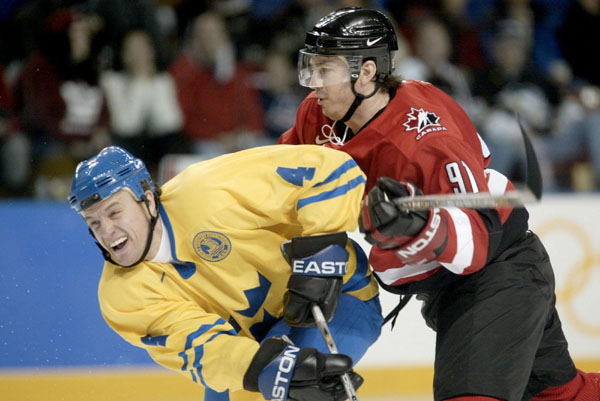 Joe Sakic (91) checks Sweden's Fredrik Olausson during a 5 - 2 Swedish win in men's hockey action at the Winter Olympics in Salt Lake City, Fri., Feb. 15, 2002.  (CP PHOTO/COA/Mike Ridewood)