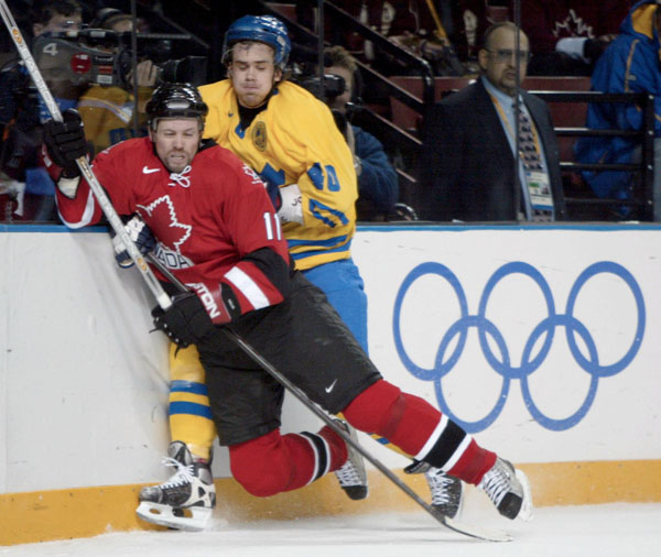 Canada's Owen Nolan (11) battles with Sweden's Henrik Zetterberg during a 5 - 2 Swedish win in men's hockey action at the Winter Olympics in Salt Lake City, Fri., Feb. 15, 2002.  (CP PHOTO/COA/Mike Ridewood)