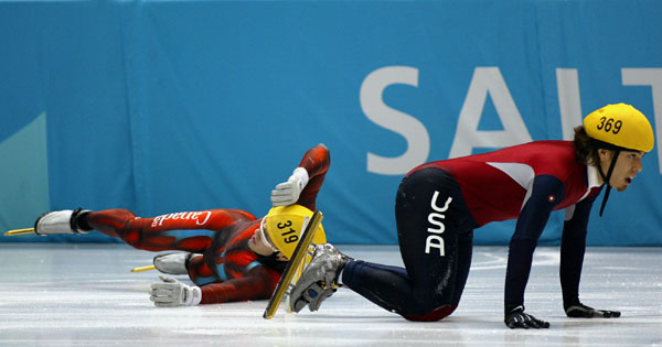 Canadian short track speed skater Mathieu Turcotte slides on the ice as American Apolo Anton Ohno is stunned on his kness during the Mens 500 metre Final in Salt Lake City, Utah Saturday Feb. 16, at the 2002 Winter Olympic Games.  (CP Photo/COA/Andre Forg