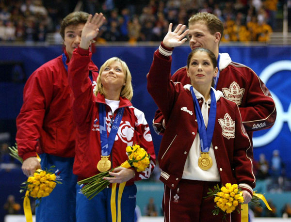 Co-Gold medalists Jamie Sale and  Elena Berezhnaya wave to the crowd as Anton Sikharulidze and David Pelletier look on after being awared double gold medals Sunday Feb. 17, at the 2002 Winter Olympic Games.  (CP Photo/COA/Andre Forget)