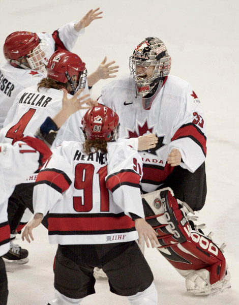 Canadian womens's hockey team goalie Kim St.-Pierre, of Chateauguay, Quebec, is mobbed by teammates after the Canadian team won the gold medal with at 3 - 2 victory over the United States in Salt Lake City , Utah during the Winter Olympics, Thursday, Feb.