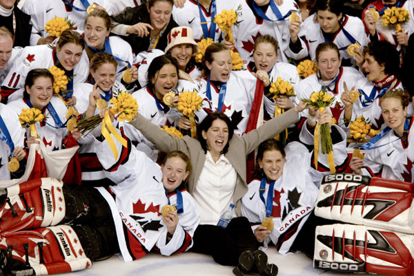 Canadian womens's hockey team coach Daniele Sauvageau (centre) and the Canadian women's hockey team pose for a team picture with their gold medal after defeating the United States 3 - 2 in Salt Lake City , Utah during the Winter Olympics, Thursday, Feb. 2