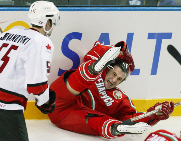 Team Belarus Vasily Pankov slides into the boards as Team Canada's Ed Jovanovski, of Windsor, Ont., skates past during the second period of Olympic hockey action Friday Feb. 22, 2002, at the 2002 Winter Olympic Games in Salt Lake City.  Team Canada went o