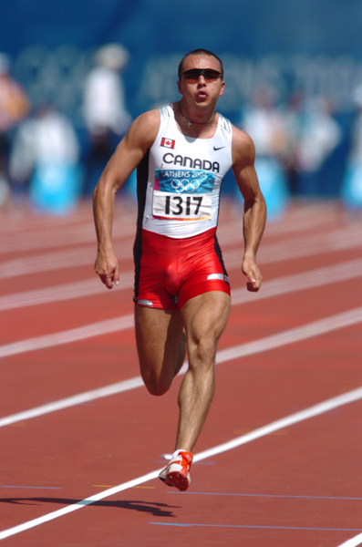 Canadian sprinter Nicolas Macrozonaris of Laval, Quebec, runs during the 100m heat during the Athens 2004 Summer Olympic Games Saturday, August 21, 2004. Macrozonaris crossed the line with a time of 10.40 to move on. (CP PHOTO/COC-Andre Forget)