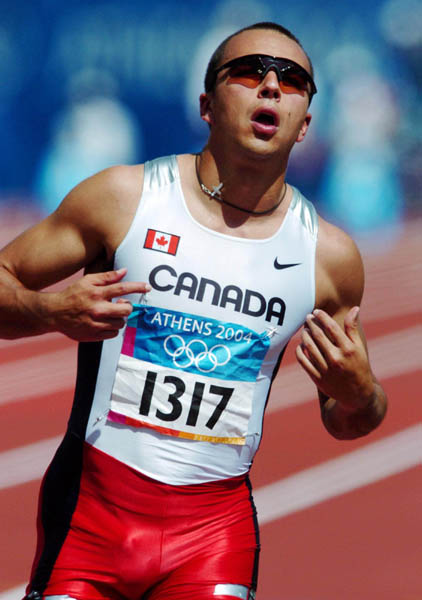 Canadian sprinter Nicolas Macrozonaris of Laval, Quebec, checks out his time after running during the 100m heat during the Athens 2004 Summer Olympic Games Saturday, August 21, 2004. Macrozonaris crossed the line with a time of 10.40 to move on. (CP PHOTO/COC-Andre Forget)