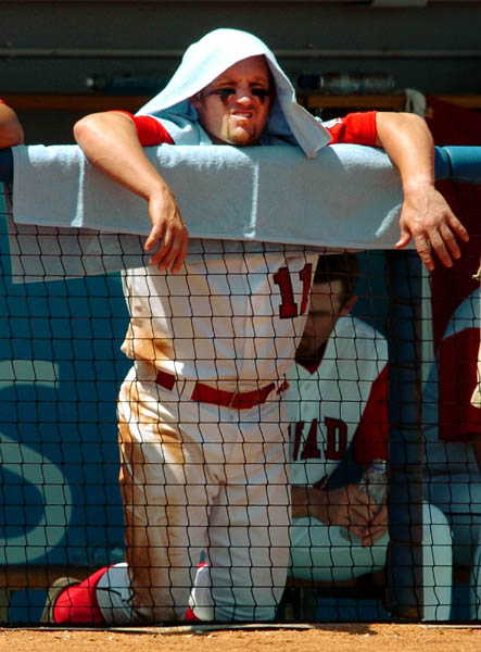 Canada's mens baseball team player Stubby Clapp covers his head with a towel as he awaits his turn at bat during bronze medal olympic baseball action against Japan during the Athens 2004 Summer Olympic Games Wednesday August 25, 2004. Japan went on to win bronze. (CP PHOTO/COC-Andre Forget)