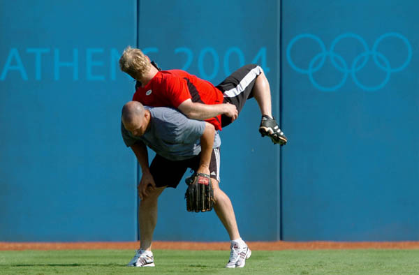 Jeff Guiel (red) and Simon Pond of the Canadian Baseball team horse around during team practice at the Athens 2004 Summer Olympic Games August 12, 2004. (CP PHOTO 2004/Andre Forget/COC)