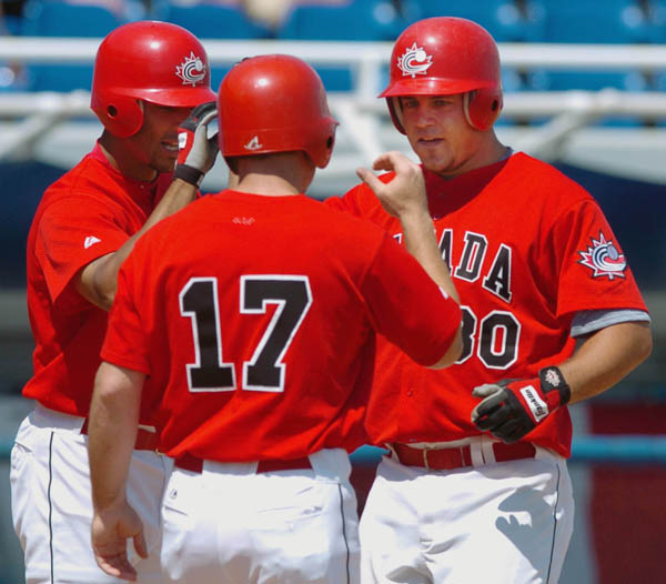 Canadian Pete Laforest (right) is congratulated by team mates Rob Ducey (left) and Danny Klassen after hitting a three-run homer during men's baseball action against Italy at the Summer Olympic Games in Athens, Greece, Monday,  August 16, 2004. (CP PHOTO/COC/Andre Forget)