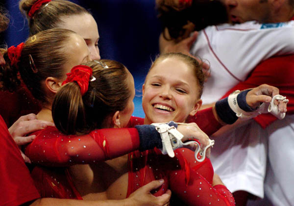 Teammates hug Gael Mackie after participating in the women's gymnastics qualifications at the 2004 Olympic Games in Athens, Sunday, Aug. 15, 2004. (CP PHOTO/COC-Andre Forget)
