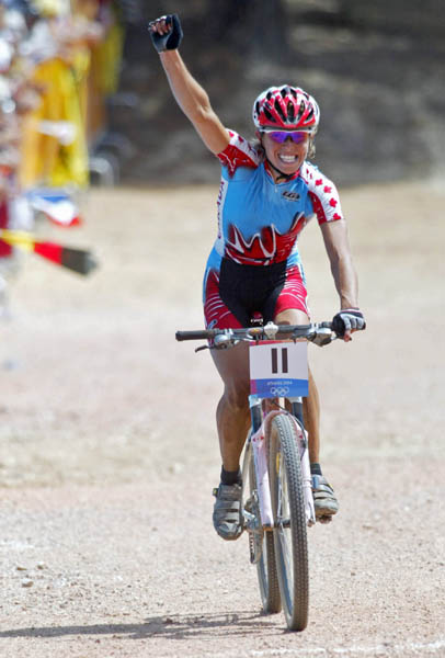Canada's Marie-Helene Premont of Chateau-Richer, Que. celebrates as she heads toward the finish line to take the silver medal in women's mountain bike action at the Athens Olympics, Friday, August 27, 2004.(CP PHOTO/COC-Mike Ridewood)