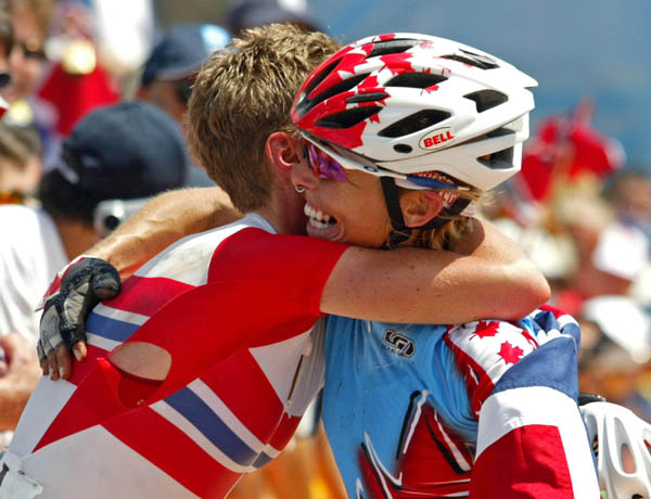 Canada's Marie-Helene Premont (right) of Chateau-Richer, Que. celebrates her silver medal in women's mountain bike with gold medalist Gunn-Rita Dahle of Norway at the Athens Olympics, Friday, August 27, 2004.(CP PHOTO/COC-Mike Ridewood)