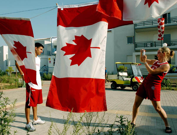 Table tennis athlete Marie Christine Roussy photographs her  teammate Faazil Rassam at the Canadian compound of the Olympic Village Monday August 9, 2004. (CP PHOTO/ 2004 COC -Andre Forget)