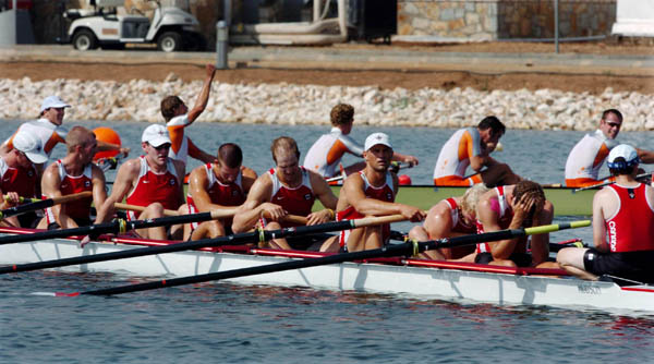 Canada's Mens Eight sit dejected after placing 5th while the Netherlands team celebrate their 2nd place rank after the final during the Athens 2004 Summer Olympic Games Sunday, August 22, 2004. (CP PHOTO/COC-Andre Forget)