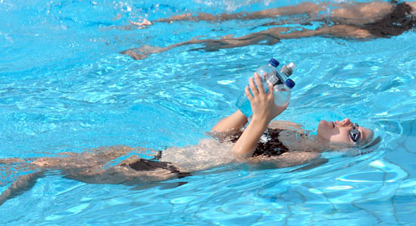 A Canadian Scynco team member swims with her bottled water during practice prior to the Athens 2004 Summer Olympic Games August 10, 2004 in Greece. (CP PHOTO 2004/Andre Forget/COC)