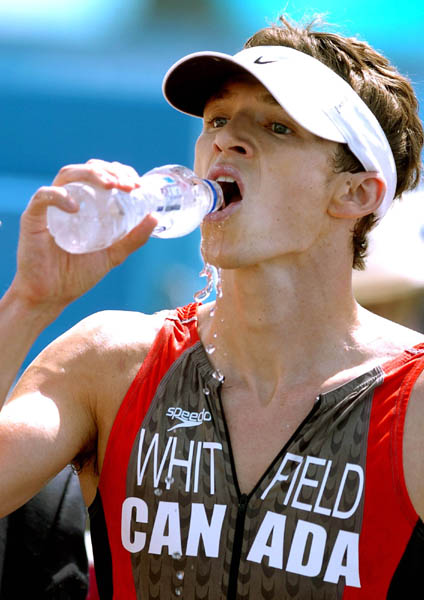 Simon Whitfield of Victoria, B.C., takes a drink of water after running in the Triathlon event at  the Athens 2004 Summer Olympic Games Thursday August 26, 2004. (CP PHOTO/COC-Andre Forget)