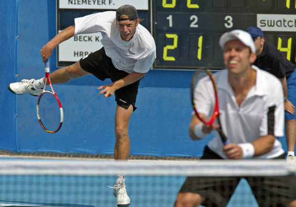 Frederic Niemeyer (background) of Campbellton, N.B. and Daniel Nestor of Willowdale, Ont. serve during their win over Slovakia in the first round of doubles tennis at the Athens Olympics, Sunday, August 15, 2004.   (CP PHOTO/COC-Mike Ridewood)