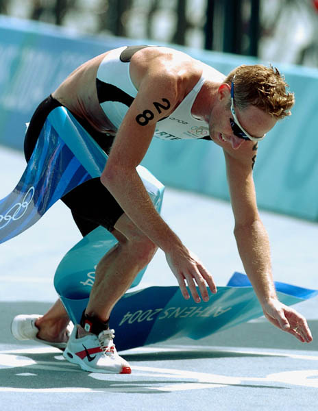 Hamish Carter of New Zealand, falls to the ground after winning the gold medal in the men's triathlon during the 2004 Olympic Games in Athens, Thursday, Aug. 26,  2004. (CP PHOTO/COC-Andre Forget)