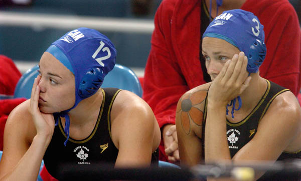 Canadian women's water polo team members Christine Robinson (left) of Montreal and Marianne Illing (right) of Ottawa sit dejected on the bench after their 8-6 loss to Russia at the 2004 Summer Olympic Games in Athens, Greece, Monday, August 16, 2004. (CP PHOTO/COC/Andre Forget)