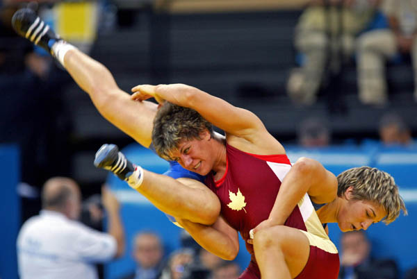 Canada's Viola Yanik (centre) of Saskatoon takes down Volha Khilko of Belaurus to claim fifth place at 63 kg. in women's wrestling finals at the Athens Olympics, Monday, August 23, 2004.(CP PHOTO)2004(COC-Mike Ridewood)