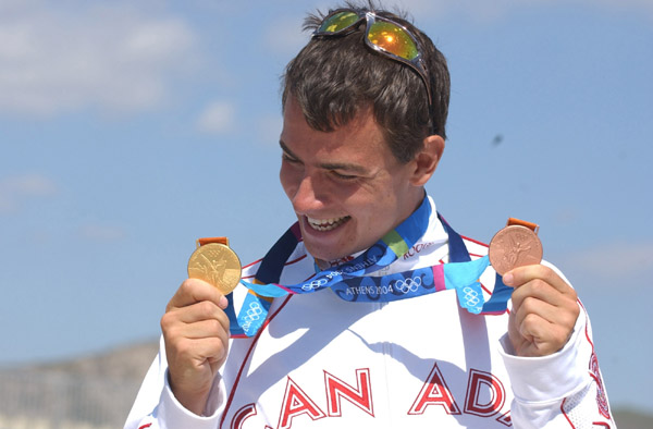 Canada's Adam van Koeverden shows his gold and bronze medals after competing at the Athens 2004 Summer Olympic Games Saturday, August 28, 2004. van Koeverden won gold in the K1 500m and the bronze in the K1 1000m kayak race. (CP PHOTO/COC-Andre Forget)