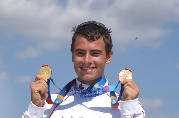 Canada's Adam van Koeverden holds up a gold and bronze medal after competing at the Athens 2004 Summer Olympic Games Saturday, August 28, 2004. van Koeverden won gold following the K1 500m on Saturday and the bronze Friday in the K1 1000m kayak race. (CP PHOTO/COC-Andre Forget)
