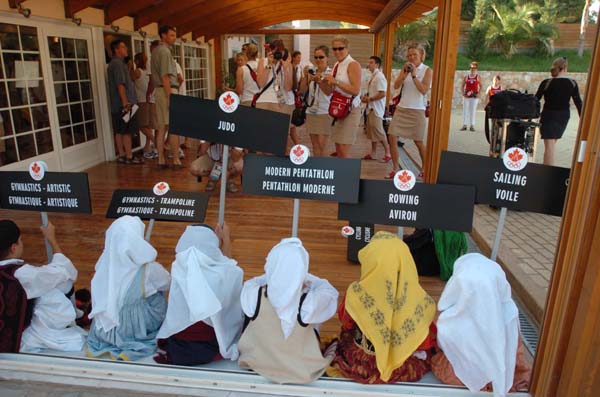 Members of the 2004 Canadian Olympic Team arrive at the team reception on August 11, 2004, while greek children are ready with sport signs. (CP PHOTO)2004(COC-Andr Forget)