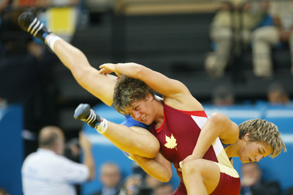Canada's Viola Yanik (red) of Saskatoon wrestles in a match of women's wrestling in the 63kg category at the Olympic Games in Athens on Sunday, August 22, 2004. (CP PHOTO/COC-Mike Ridewood)