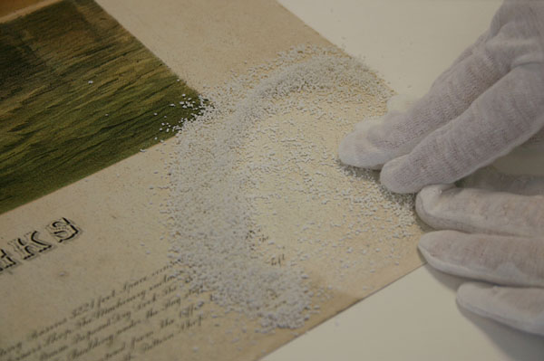 The first step was to remove as much of the surface dirt as possible. The recto of the lithograph was dry cleaned using ground white vinyl eraser: the crumbs were rolled across the surface with a light pressure to avoid pushing the dirt into the paper fibres.
