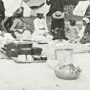 Photograph of a group of Aboriginal men and women seated on the ground at a feast, Mattagami, July 1906