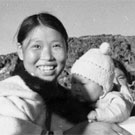 Photo de feu Timothy Ottochie (à gauche) et d'Aukshuali (au centre) tenant son bébé dans ses bras; deux femmes inuites sont debout à droite, Cape Dorset (Kinngait), Nunavut, 1948