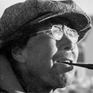 Photo d'un homme inuit portant des lunettes et un chapeau, et fumant une pipe, Pangnirtung (Pangnirtuuq), Nunavut, août 1946