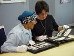 Photo de l'aîné Abraham Ulayuruluk et Joanna Quassa regardant un album de photos d'Inuits dans les collections de Bibliothèque et Archives Canada, Ottawa, octobre 2005