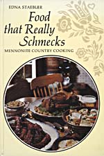 Cover of cookbook, FOOD THAT REALLY SCHMECKS: MENNONITE COUNTRY COOKING, with a round photograph of a table covered with food