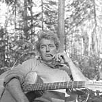 Photograph of Félix Leclerc in the woods, with his guitar