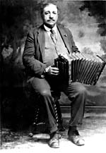 Photo d'Alfred Montmarquette, assis, tenant son accordéon