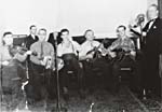 Photograph of Les Gaîtés canadiennes, March 1944, showing: Soucy, fiddle; Donat Lafleur, accordion; Aldor Morin, harmonica; Jack Dabaté, mandolin; Edgard Morin, guitar; Conrad Gauthier, folklorist; René Delisle, piano